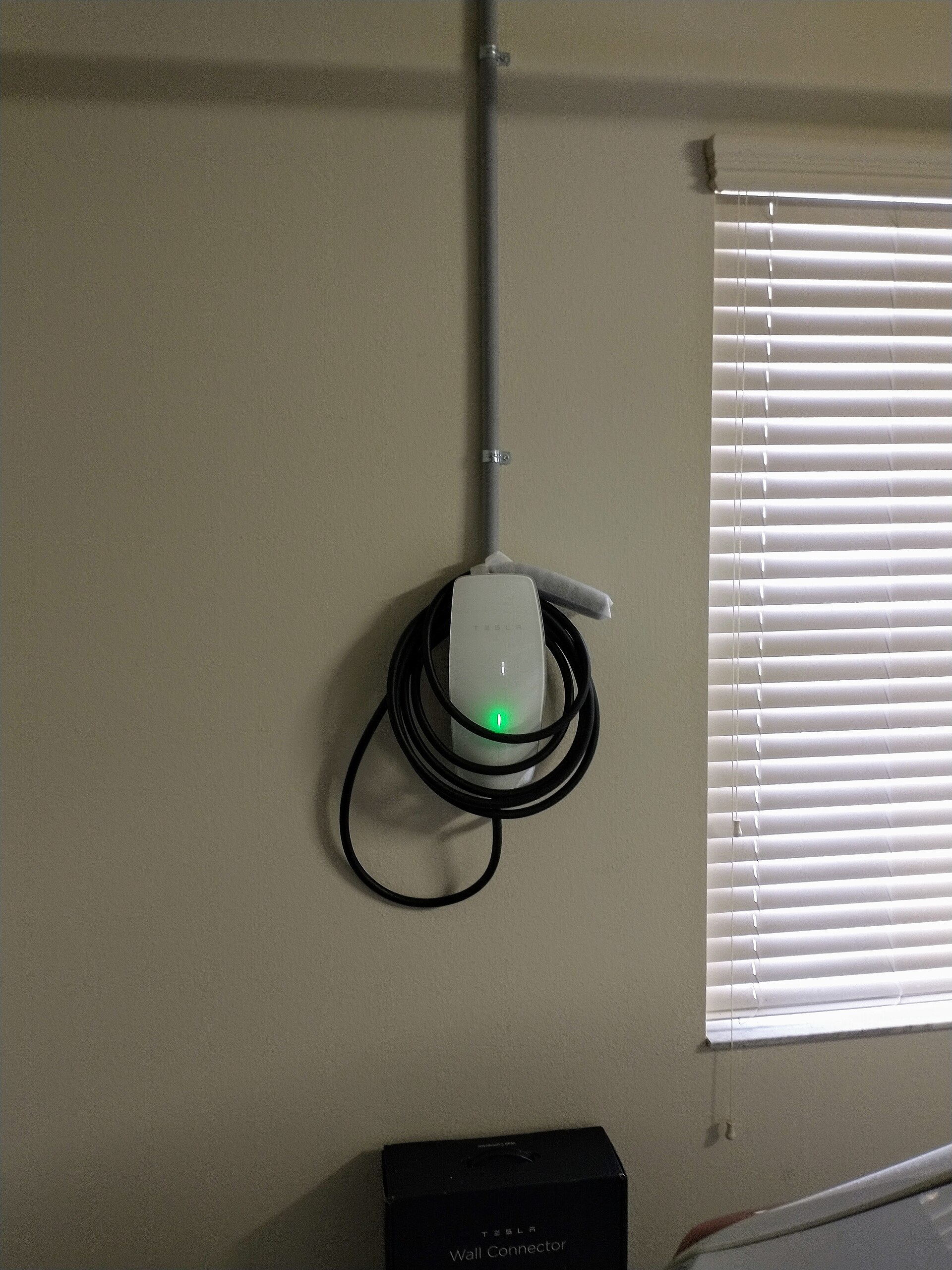 شاحن Tesla Wall Connector حقيقي مركب في مرآب منزلي